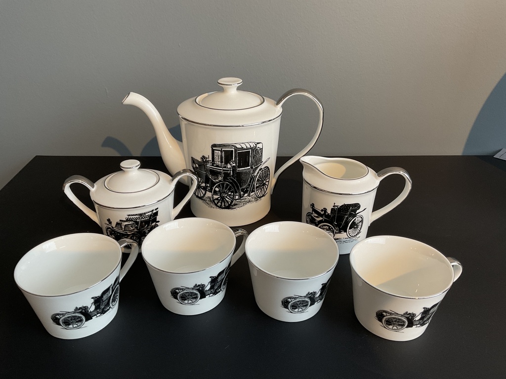 A tea serving set with an old car drawing on it